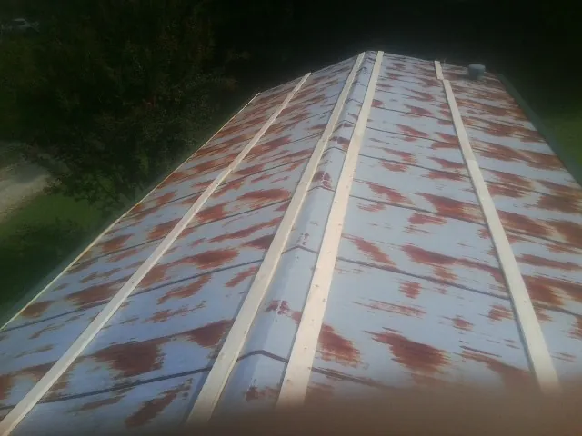 Rusted metal roof panels with new wood purlins before replacement — Storm Damage Roof Repair in Rollinsford by Roofing Brothers